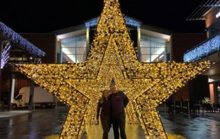 3D light up gold star motifs displayed in a row outside the entrance of the shopping centre.