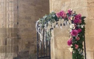 Selfie bench decorated with greenery and pink roses displayed outside Lincoln Castle.