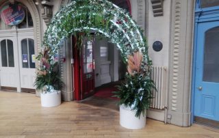 Light up greenery arch displayed outside a doorway entrance in Leeds corn exchange shopping centre.