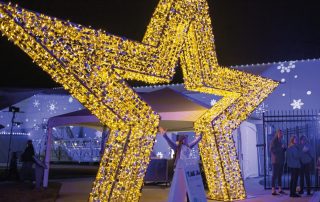 Light up gold star motif displayed outside the entrance of an outdoor event.